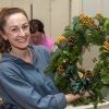 A woman holding a wreath that she has made at a Christmas wreath-making class