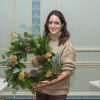 Lady holding a Christmas wreath made at a workshop run by Just So Flowers.