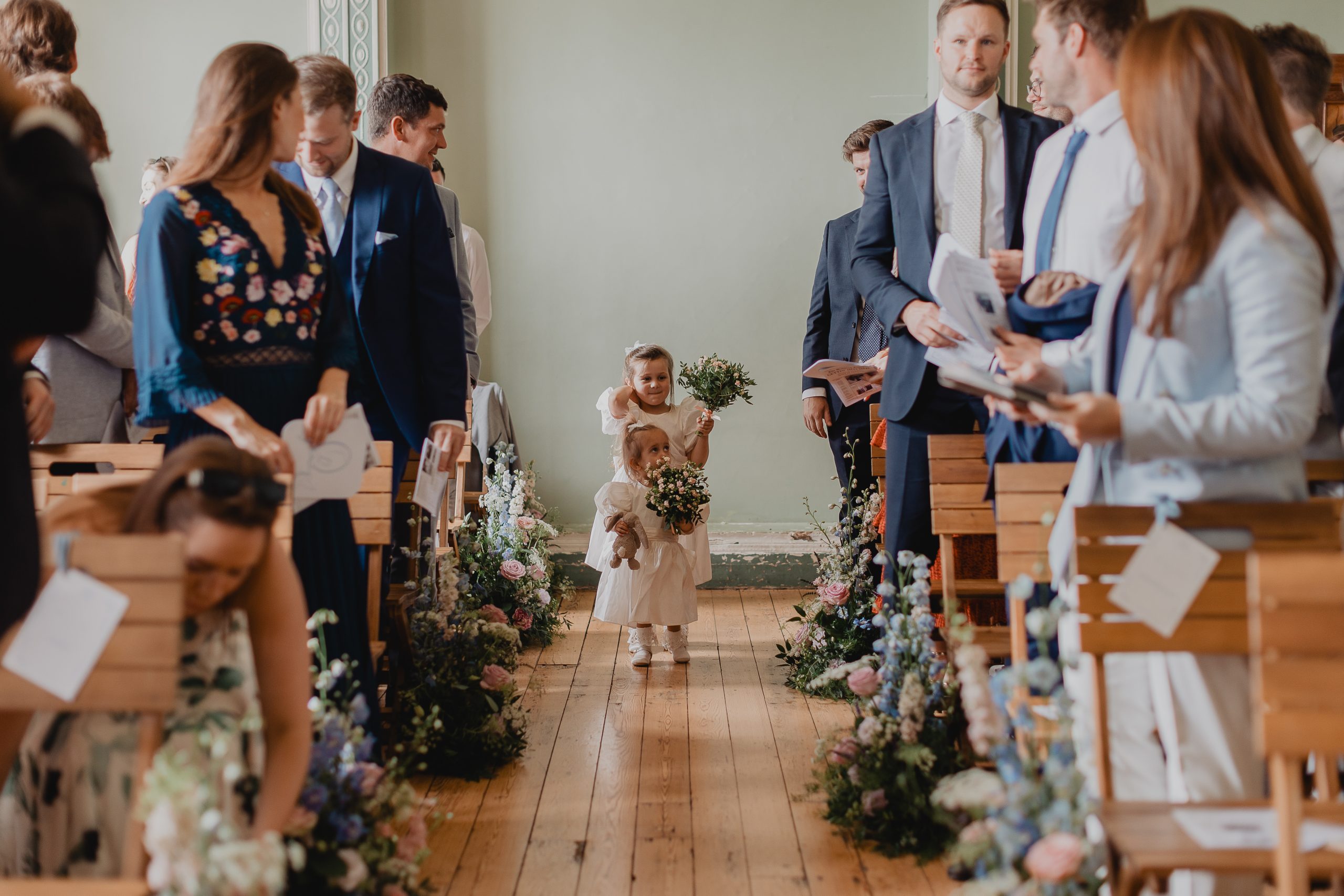 Little flower girls walking down the aisle at Beckenham Place Mansion with Flowers by Just So Flowers